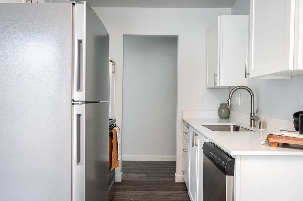 a kitchen with white cabinets and a stainless steel refrigerator